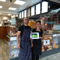 Photo of restaurant owners holding certificate