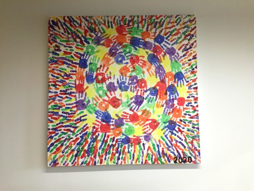 A painting of many childrens' handprints