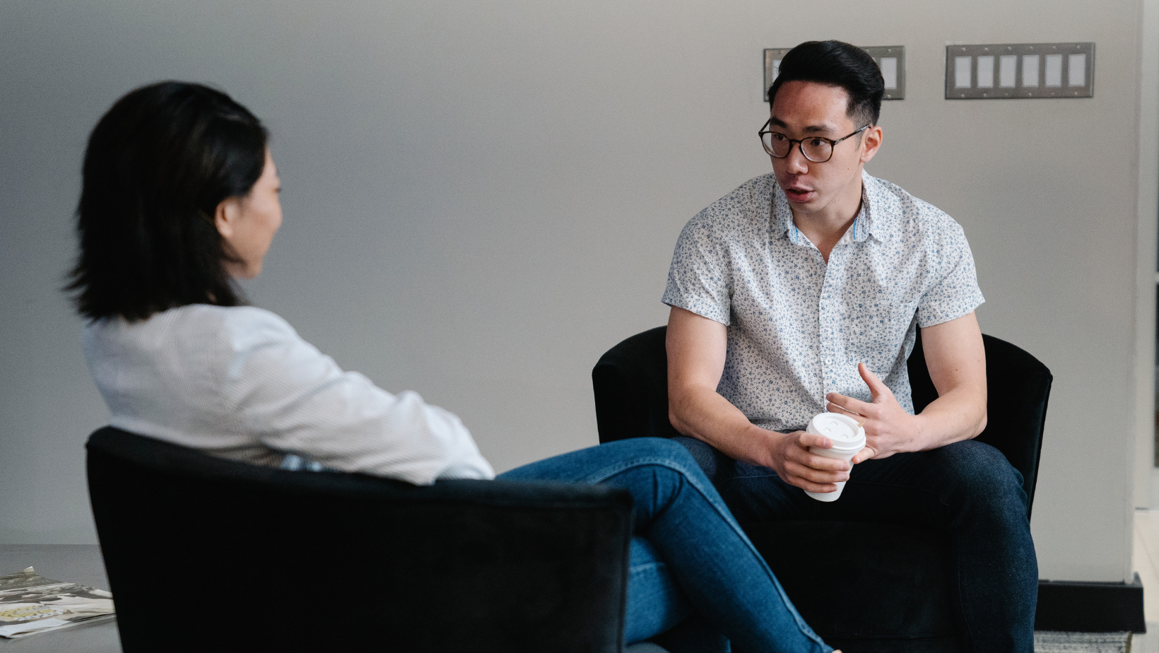 A man and woman sitting down having a discussion.
