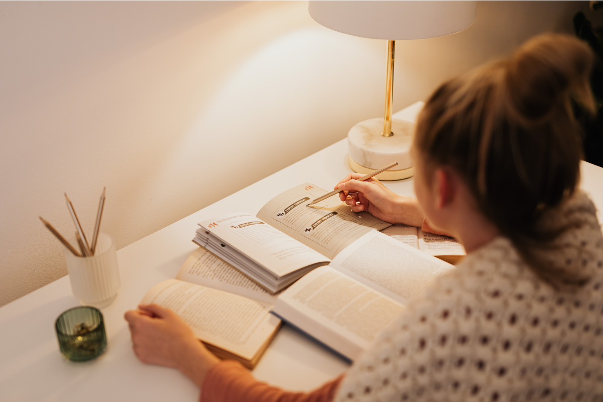 Lady sitting at a table reading books and studying