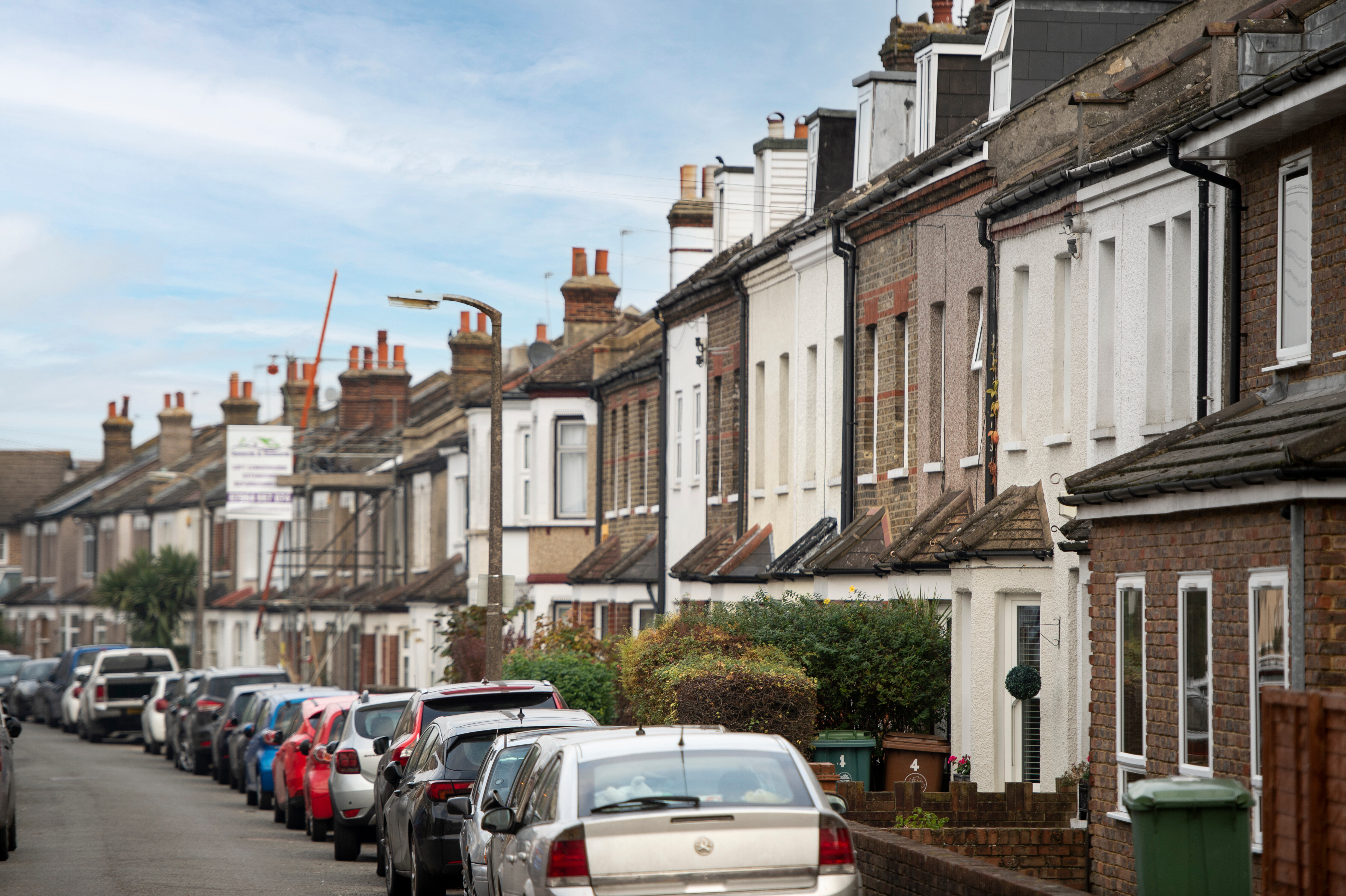 Picture of houses on a street with cars parked outside